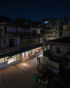 Concrete exterior of a modern restaurant with glass storefront and steel detailing at night.