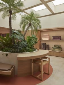 A modern retail shop featuring industrial design elements with concrete floors, wooden furniture, and glass displays.