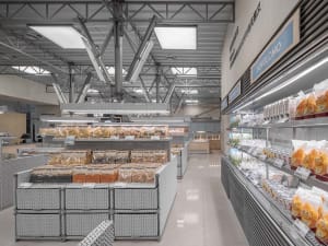 A modern industrial supermarket with metal shelving units displaying various food items.