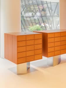 A modern interior featuring an orange furniture display with multiple drawers.