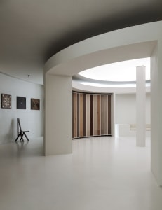 Minimalist white interior with wood, concrete and plaster elements.