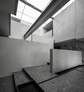 An interior space featuring white marble and concrete elements