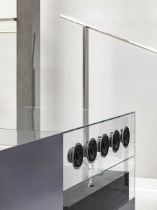 A modern interior space featuring a glass balustrade with a minimalist design.