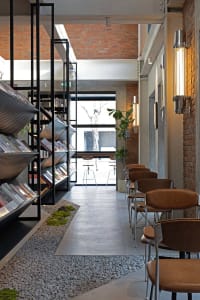 Interior of a minimalist library with brick walls, concrete flooring, and glass elements.