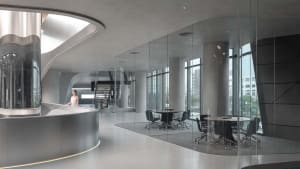 A modern conference room featuring glass walls and concrete columns.