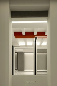 A modern office space featuring white concrete walls and floors with a vibrant red ceiling beam