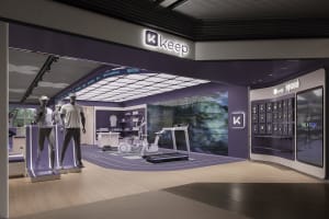 A modern retail fitness store with a purple interior design, featuring various fitness equipment and merchandise.