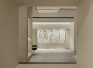 Minimalist retail storefront showcasing white clothing on a minimalist concept.