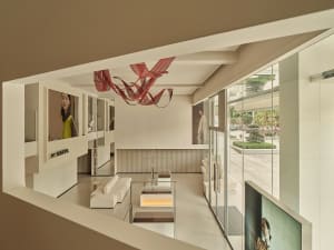 Interior of a modern architecture glass retail shop with a minimalist design and artistic ceiling sculpture.