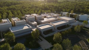 Aerial view of a modern concrete building complex surrounded by trees.
