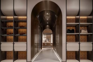 Clothing storage corridor featuring metallic shelving, patterned tiles, and illuminated walkway.