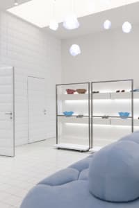 A minimalist retail space featuring metal, glass, and fabric elements.