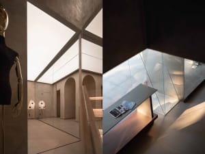 Modern industrial style library featuring grey concrete walls, glass walls, and large windows.