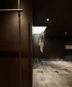 An industrial-style interior design featuring metal walls and stone flooring.