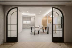 A minimalist modern home office with a concrete floor and white walls.