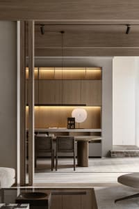 A modern home office with wooden furniture and floor-to-ceiling shelves.