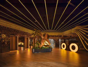 A modern lobby featuring metallic and wooden architectural elements.