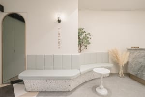A modern lobby with a curved, terrazzo-finished bench and minimalist design elements.