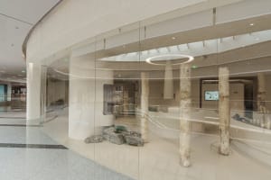 Modern shopping center featuring glass, concrete, and stone materials.