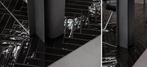 A modern floor with black tiles in a herringbone pattern.