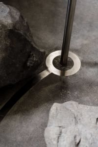 A modern interior with a metal base holding a vertical rod.