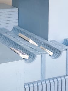 Concrete blocks and rectangular blocks stacked on a blue surface.