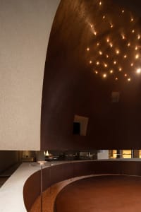 An interior space with a minimalist design featuring clay and metal materials.