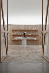 Modern art gallery with wooden shelves and a concrete table