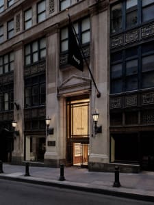 The entrance of a modern retail storefront, featuring a stone facade and glass windows.