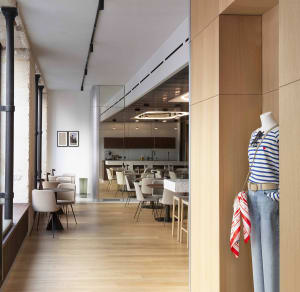 A modern cafeteria interior with wooden floors, glass walls, and metal accents.