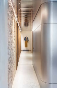 A modern interior corridor made of aluminum with a minimalist design and white speckled flooring.