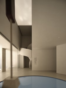Concrete spiral staircase leading to a swimming pool in a modern interior space.