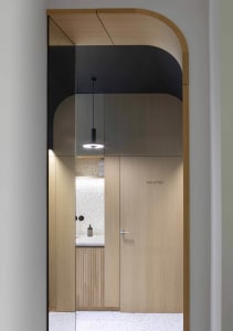 Modern minimalist bathroom with wood accents and a terrazzo floor.