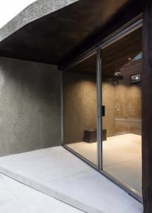 Modern retail store entrance featuring large glass doors and a concrete ground.