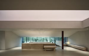 A modern residential space featuring a minimalist design with concrete walls and floors.