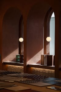 A cozy cafe interior featuring warm lighting, cement-tile surfaces, and modern fixtures.