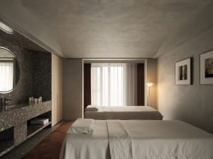 A minimalist bedroom featuring a bed with white bedding and a terrazzo sink, set against a textured wall and floor.
