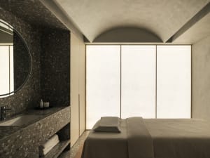 A modern bedroom with terrazzo flooring and a minimalist design.