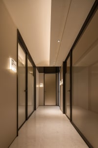 A modern corridor with glass doors and marble flooring.
