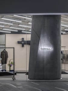 Modern retail storefront with a concrete pillar and metal accents.