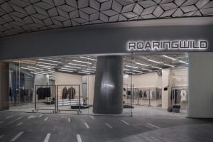 A modern storefront with glass walls and a concrete pillar.