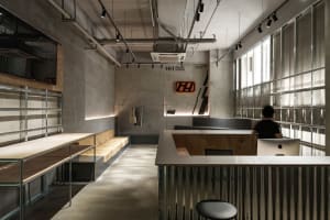 Modern industrial-style reception desk with concrete, metal, and wood in a dance studio setting.