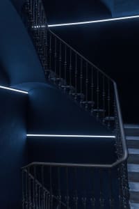 A metal staircase against a deep blue background
