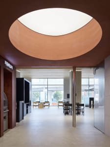 Modern interior design featuring concrete walls and a large circular window