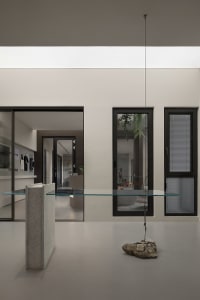 A modern interior featuring glass, concrete, and metal elements.