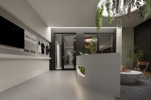 Modern office space with concrete walls, glass doors, and green foliage planters.