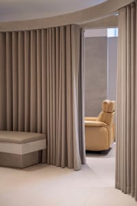 A minimalist interior designed with neutral-toned fabrics, featuring a sleek, modern living area with a comfortable seating a