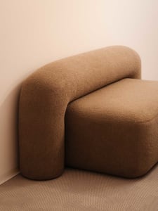 Modern sofa in a living room setting, upholstered in a beige fabric.