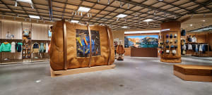 An accessories shop with a wooden display, showcasing various fashion and outdoor gear.