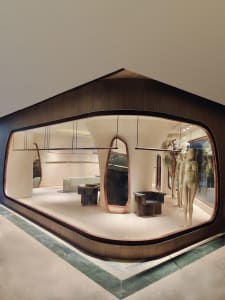 Modern retail shop interior with concrete finishes, minimalist design, and furniture.